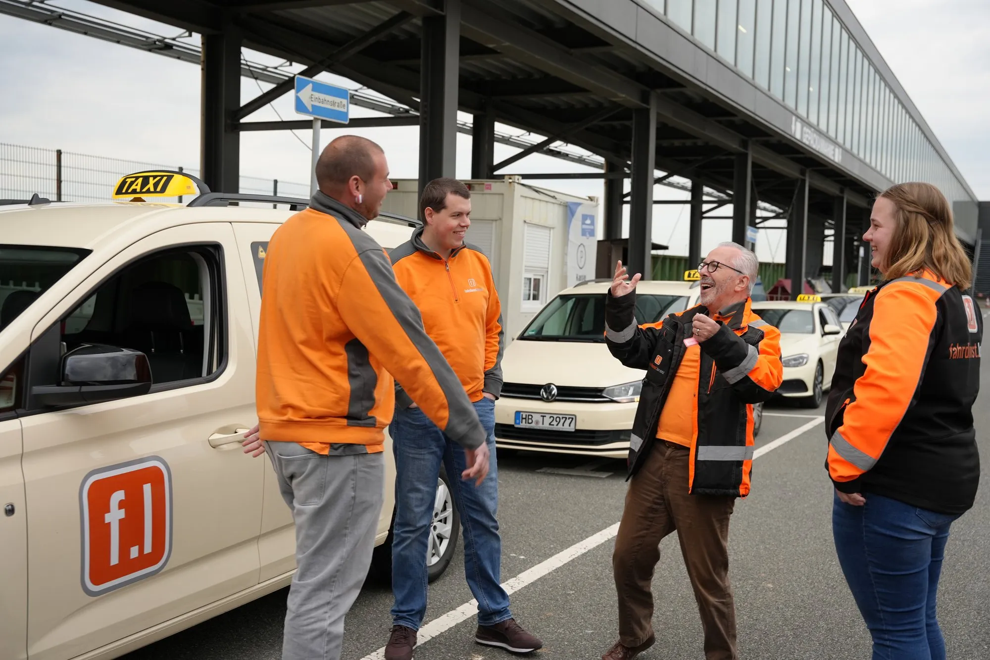 Fahrdienst Lorenz – Team im Gespräch vor einem Fahrzeug der Flotte